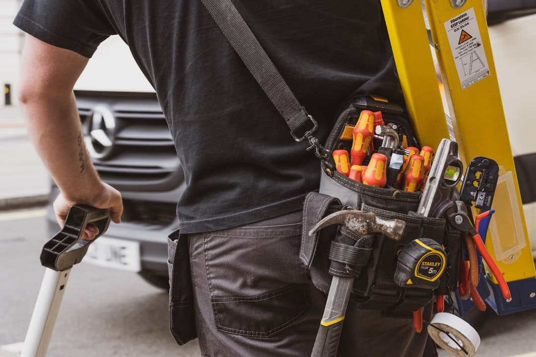 A tradesman checking his phone beside his van.
