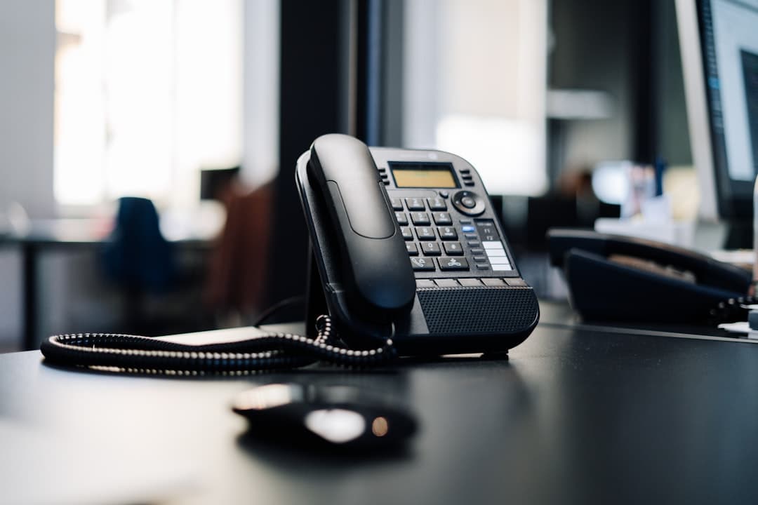 A desk phone and headset in a small office.