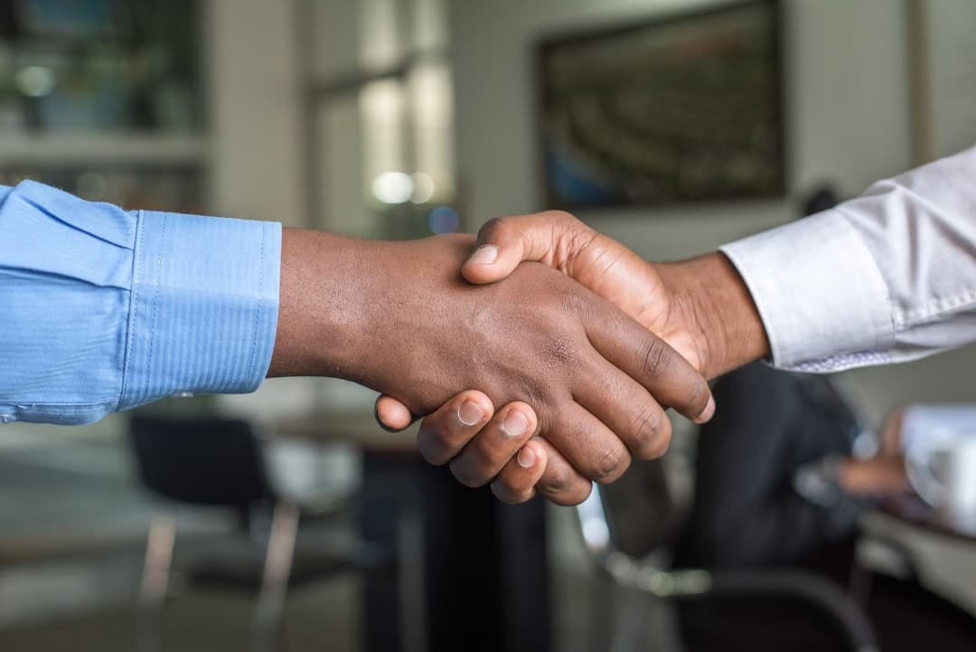 Two businesspeople shaking hands on a deal.